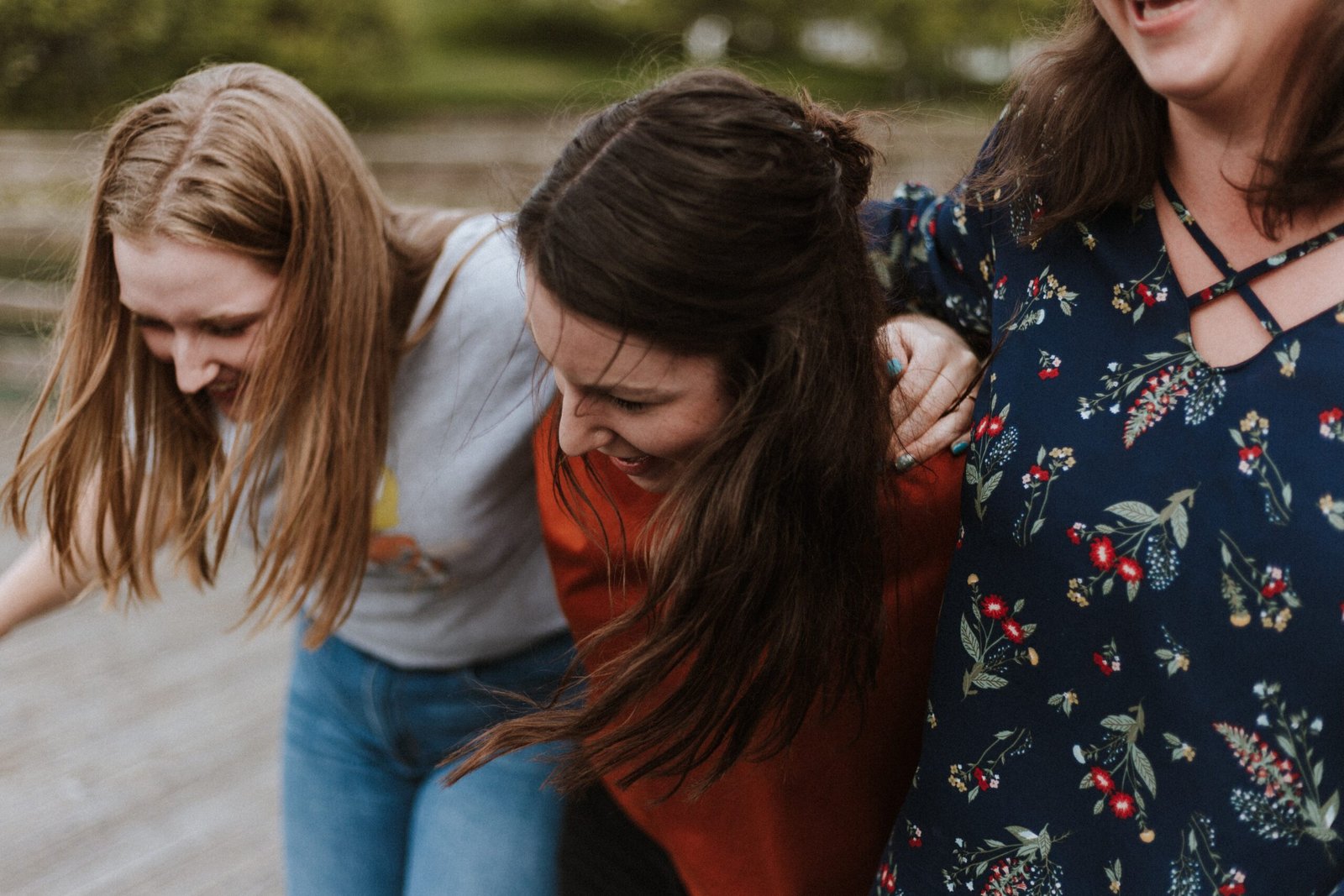Three women laugh as they walk towards the camera